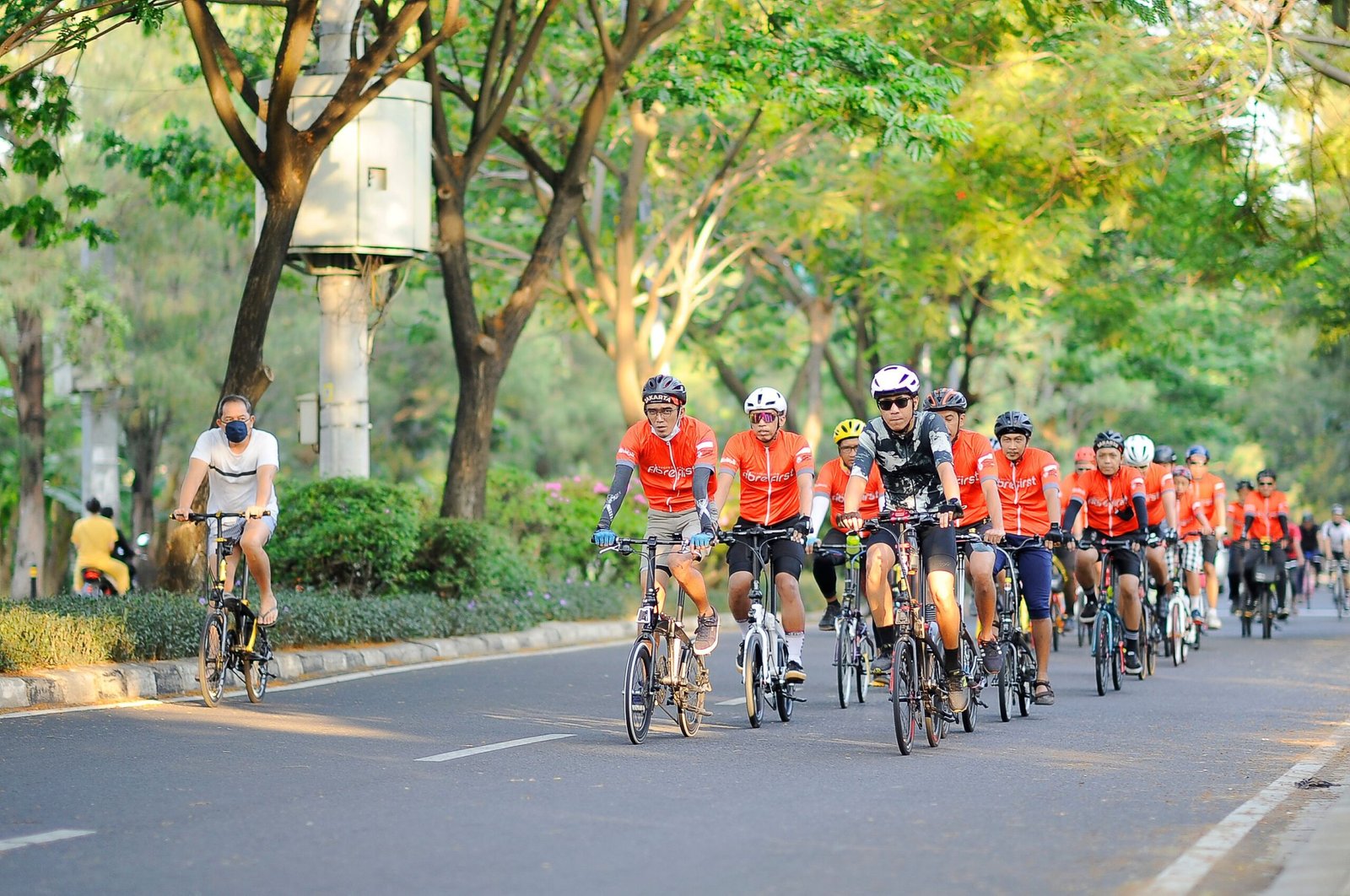 Cyclists enjoying a group ride on a sunny day in Jakarta, creating a vibrant outdoor scene.